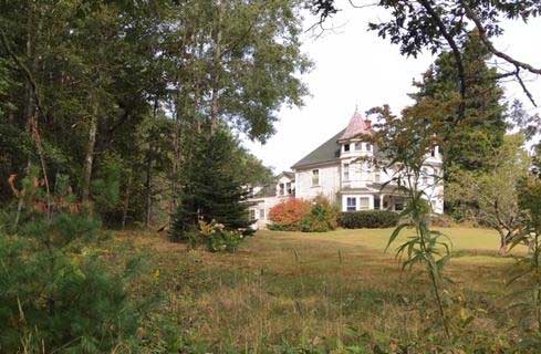 The fields are grown up in this 2020 photo of that lovely house.