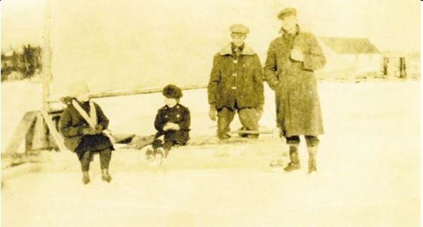 An ice boat or ice sled: Abbie and Helen Sargent are on the ice boat that is said to have gone to Brooklin and back (on the ice) in 7 minutes.  Isl Hooper is standing in this photo and Wynes Haskell is kneeling next to him.