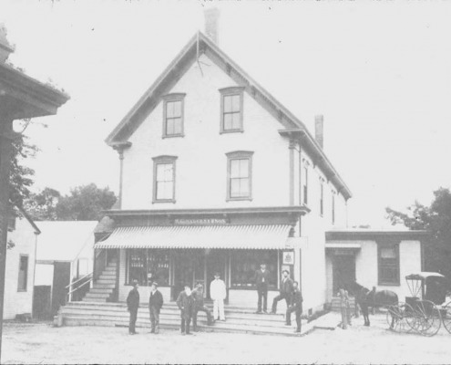 W. G. Sargent store with the Post-Office on the right. You can see the mail truck, and people on the steps waiting for the mail to be sorted.