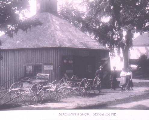 There were several blacksmith shops in Sedgwick. This one was located between Mrs. Cousins and Mrs. Choate near the former Sedgwick Store.