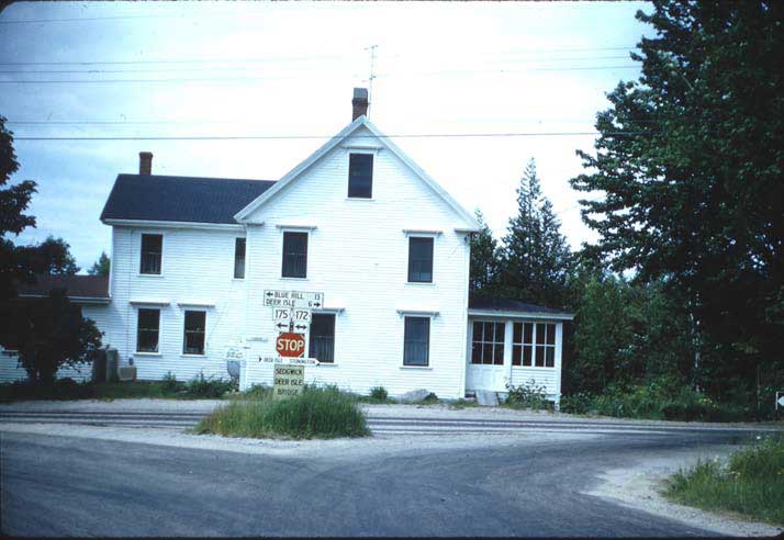 This is the house in the 1960s. The House by the Side of the Road sign can still be seen just to the left of the stop sign. At the time of the photo, the house was owned by the Torrey family.