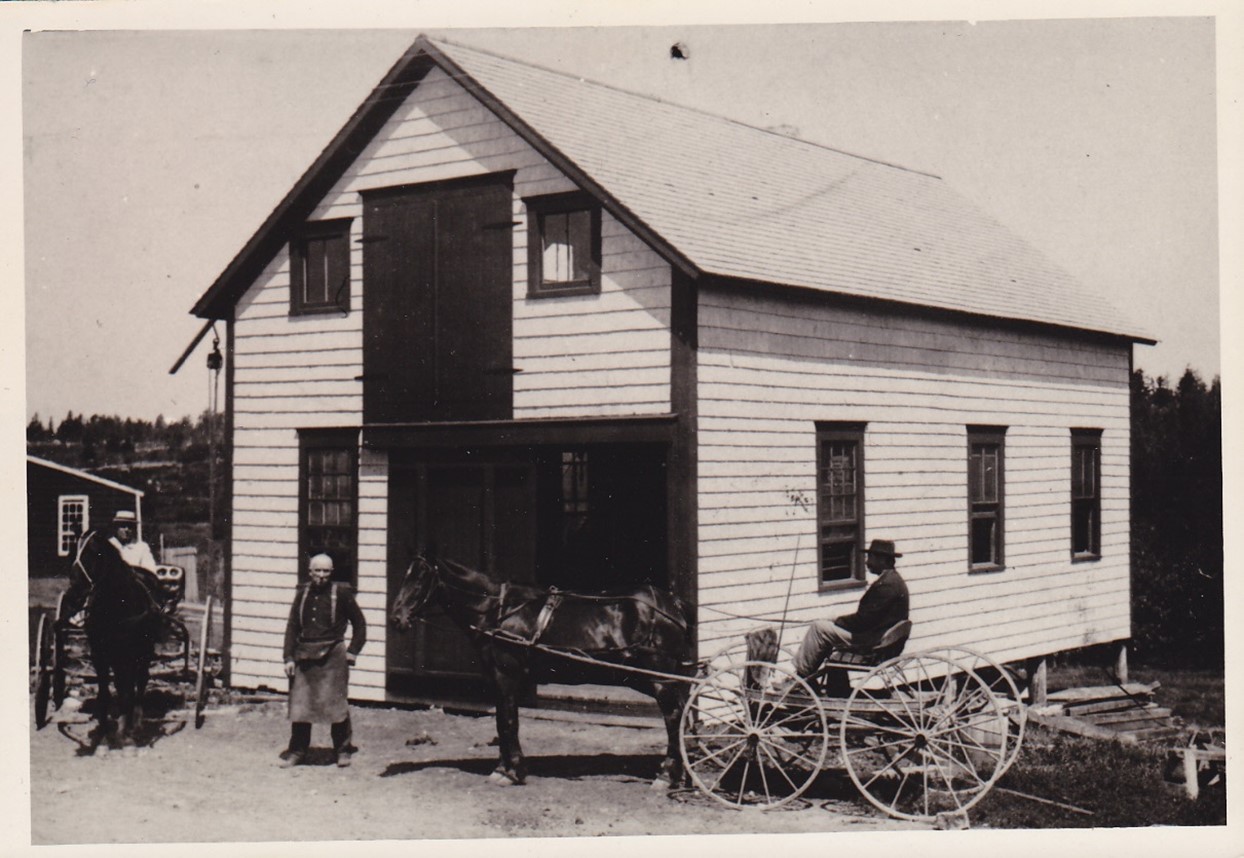 In this photo John W. Allen is standing in front of his blacksmith shop on Reach Road. The building has been renovated and is now used by Horace Wardwell for repairs on Wardwell Oil equipment.