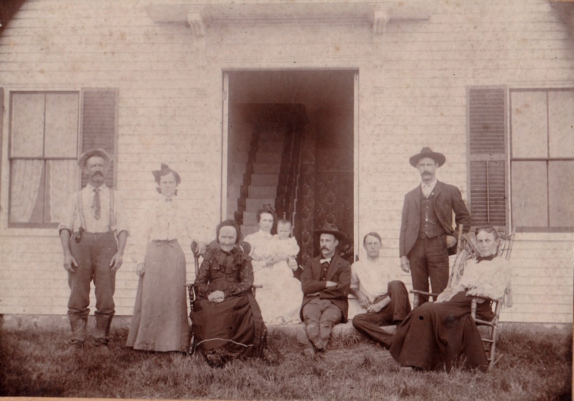 L-R Capt. Edward Alphonso Byard, Betsy Maria daughter of Edward A., Maria Trussell Byard (in rocker) mother of Edward A. and wife of Hezekiah.  In doorway, Alice Blodgett wife of Edward J. Byard holding son Paul, Edward J. is next to her, two sons of Edward A. Carl H. and John A. then Edward A. Byard’s wife Abigail Eaton Byard